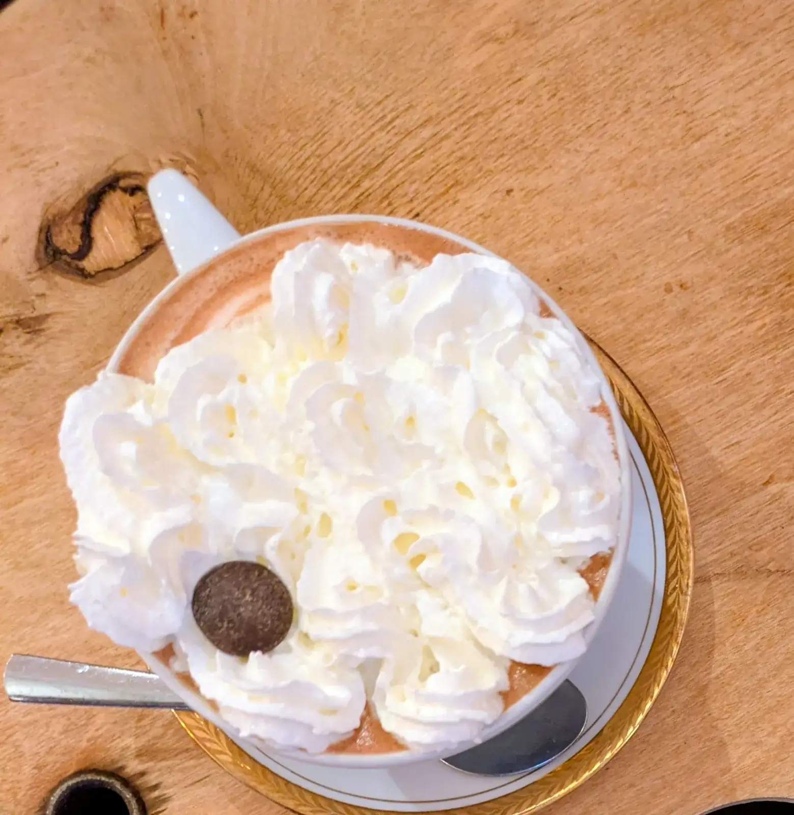 Chocolat chaud à la chantilly d’À Ton Aise à Lorient, sur une table en bois