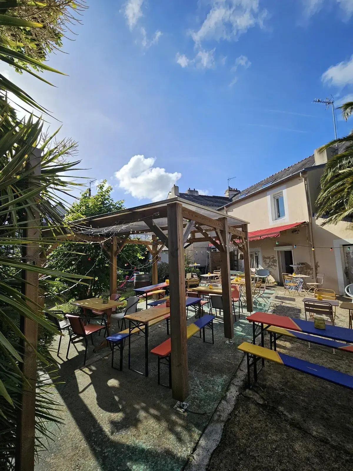 La terrasse-jardin d’À Ton Aise à Lorient, tables et bancs colorés sous la pergola